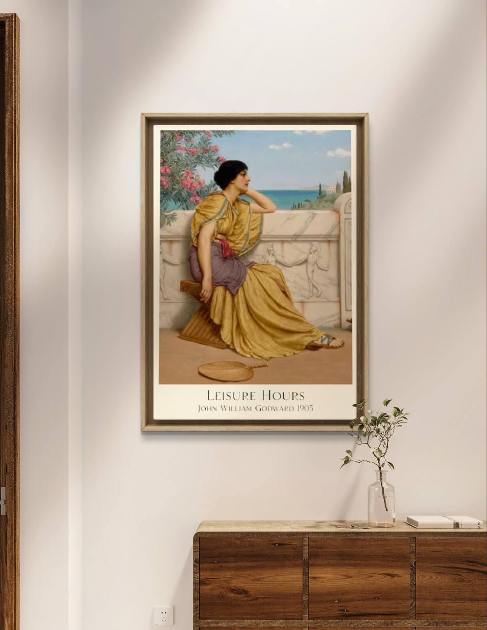 The "Leisure Hours" poster by Godward hangs on a minimalist wall, above a wooden console with a decorative plant. An elegant addition that stands out in any modern space. Keywords: Home Gallery Wall, Art Print, Home Decoration, Poster.