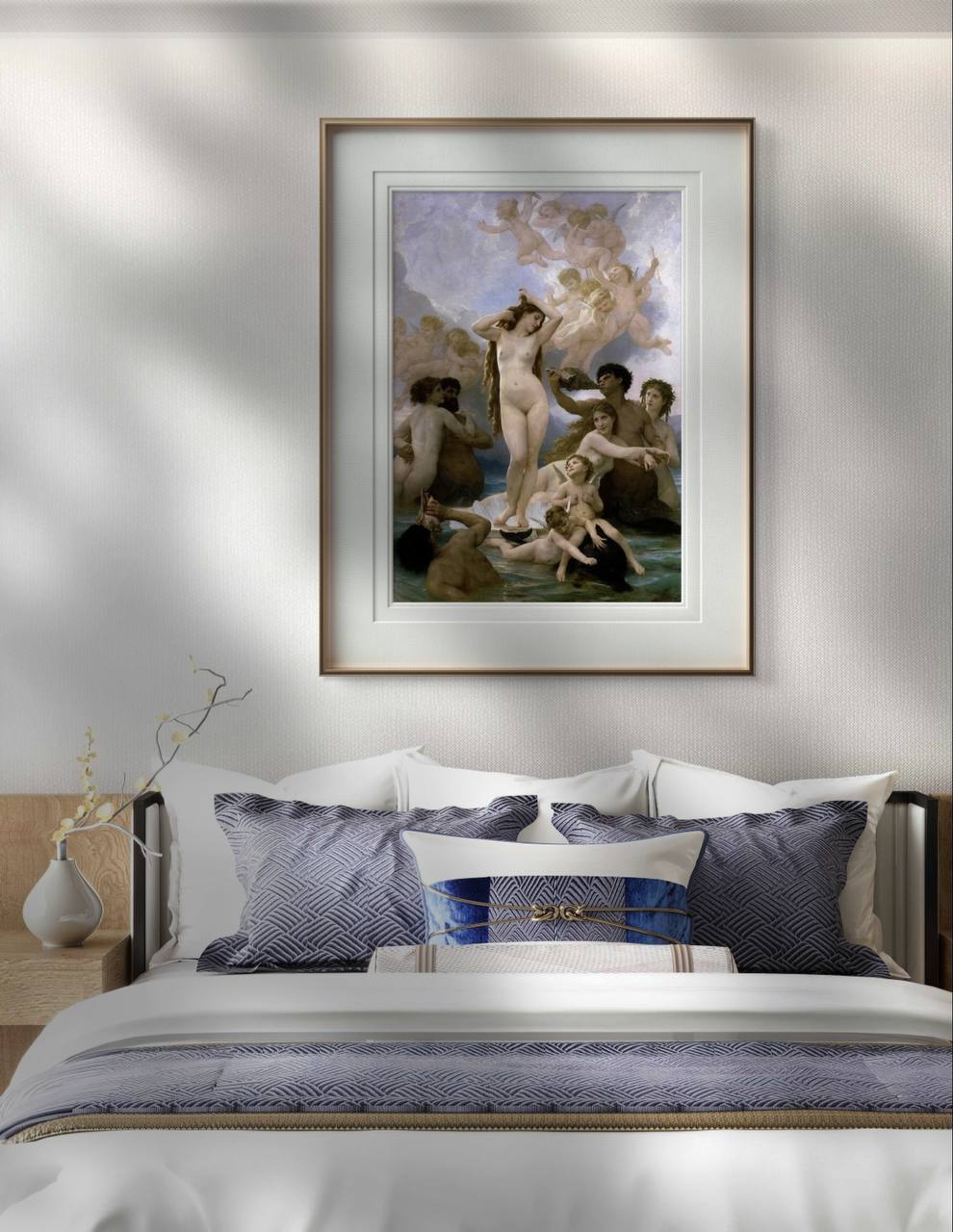 A framed painting of "The Birth of Venus" hangs above a neatly made bed with patterned blue pillows. The elegant classical artwork contrasts with the modern, minimalist bedroom decor.