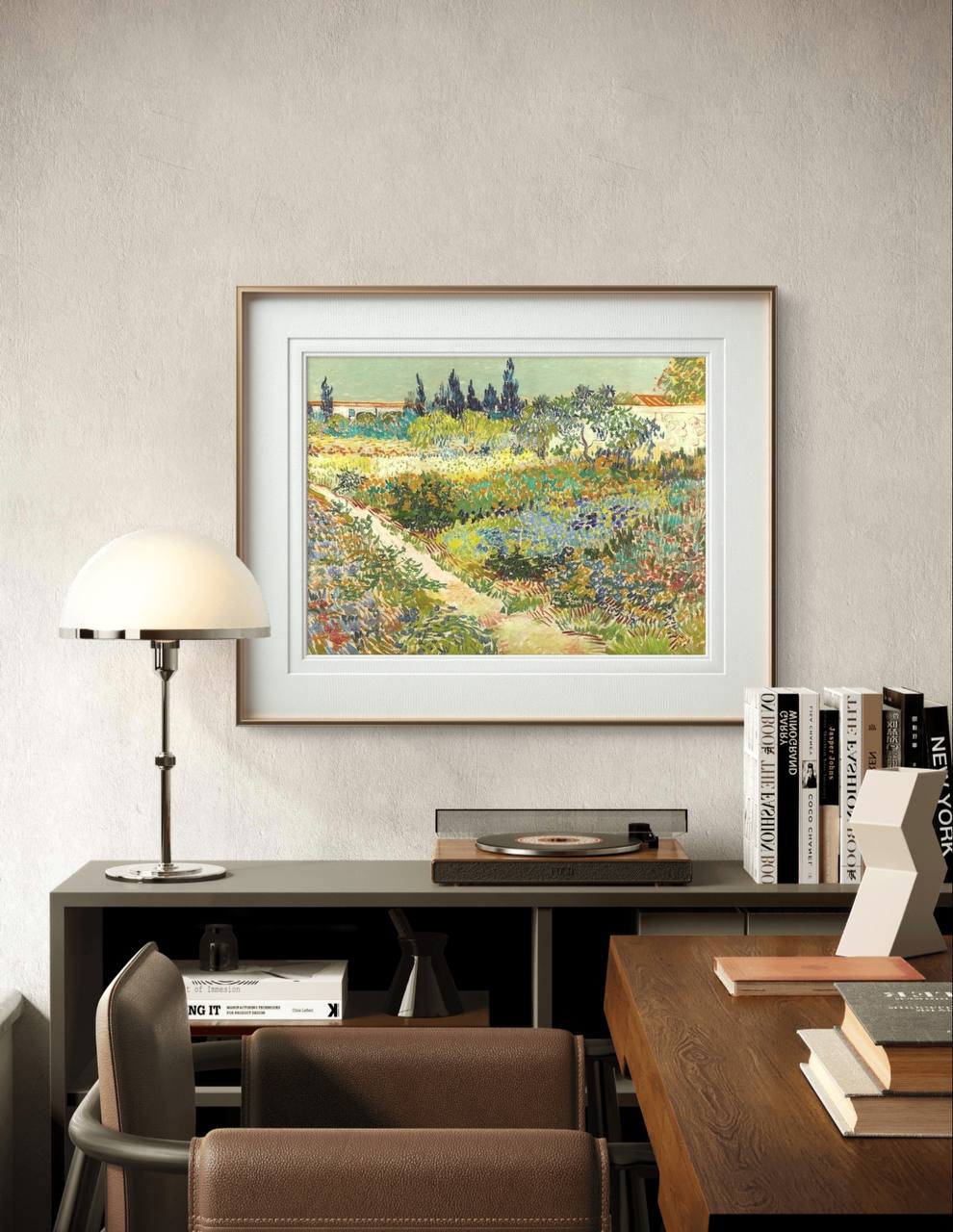 A framed Van Gogh-style garden painting displayed above a modern wooden desk with a record player, books, and a lamp. The room's decor is minimalistic, highlighting the painting's bright colors and natural beauty.