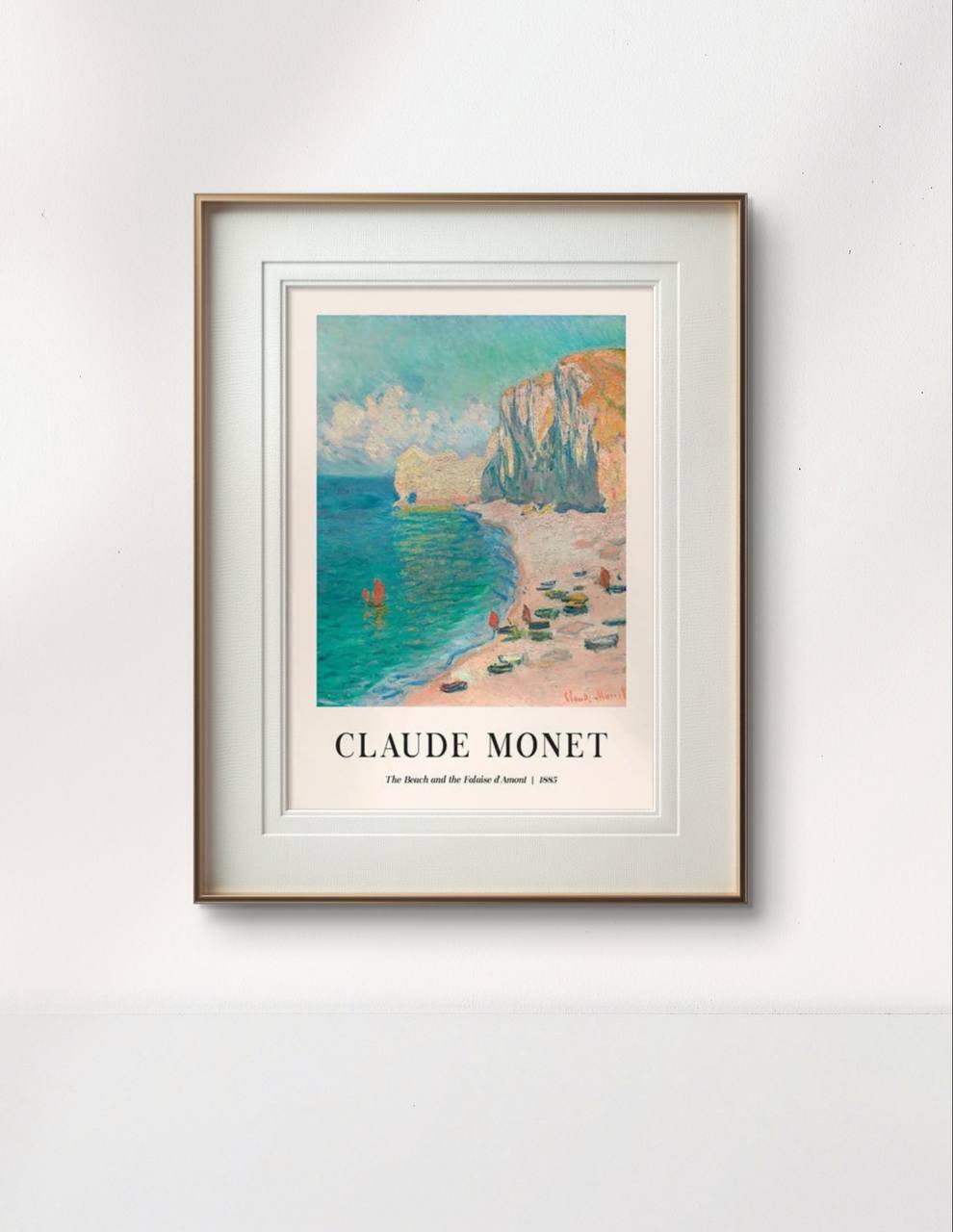 The same beach and cliff painting is framed in a wooden frame with white matting. The serene, pastel colors of the shore and sea are complemented by the simplicity of the frame.