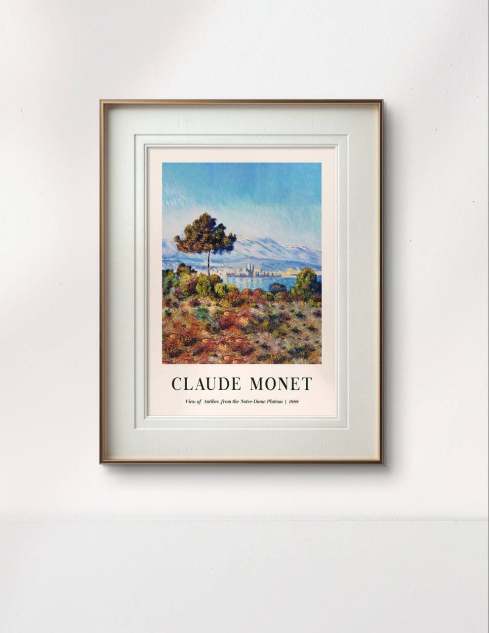 The framed painting showcases a view of Antibes with a vibrant blue sky and lush greenery in the foreground. The simple, elegant frame brings the artwork to life, adding depth and brightness to the surrounding space.