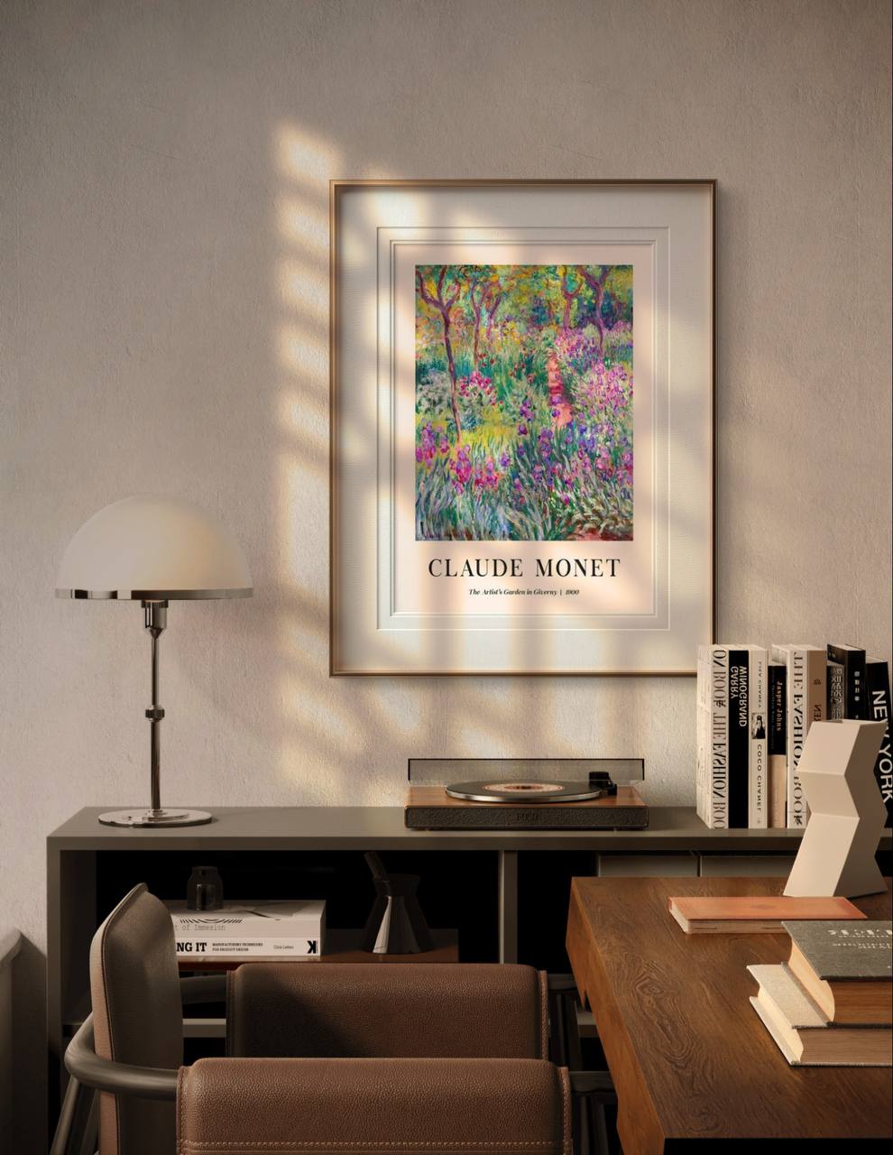 The Monet poster "The Artist's Garden in Giverny" is framed and illuminated by soft sunlight, adding a lively touch to a modern room with books and a desk.