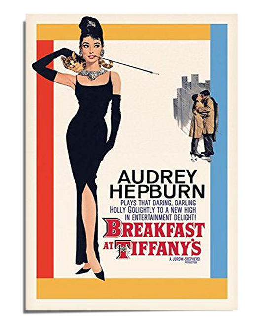A vintage movie poster featuring Audrey Hepburn as Holly Golightly in the classic film Breakfast at Tiffany’s. She is dressed in a sleek black evening gown, wearing long black gloves, a pearl necklace, and holding a long cigarette holder. To the right, a smaller illustration of a couple in a romantic embrace is set against a cityscape background. The typography includes Audrey Hepburn’s name in bold black letters and the movie title in a distinctive red and white font. The edges of the poster have blue and