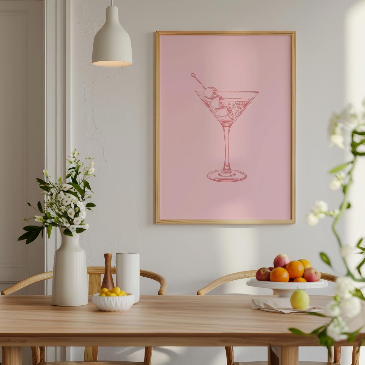 Dining room with a pink framed artwork of a cocktail, table with fruit and decor items.