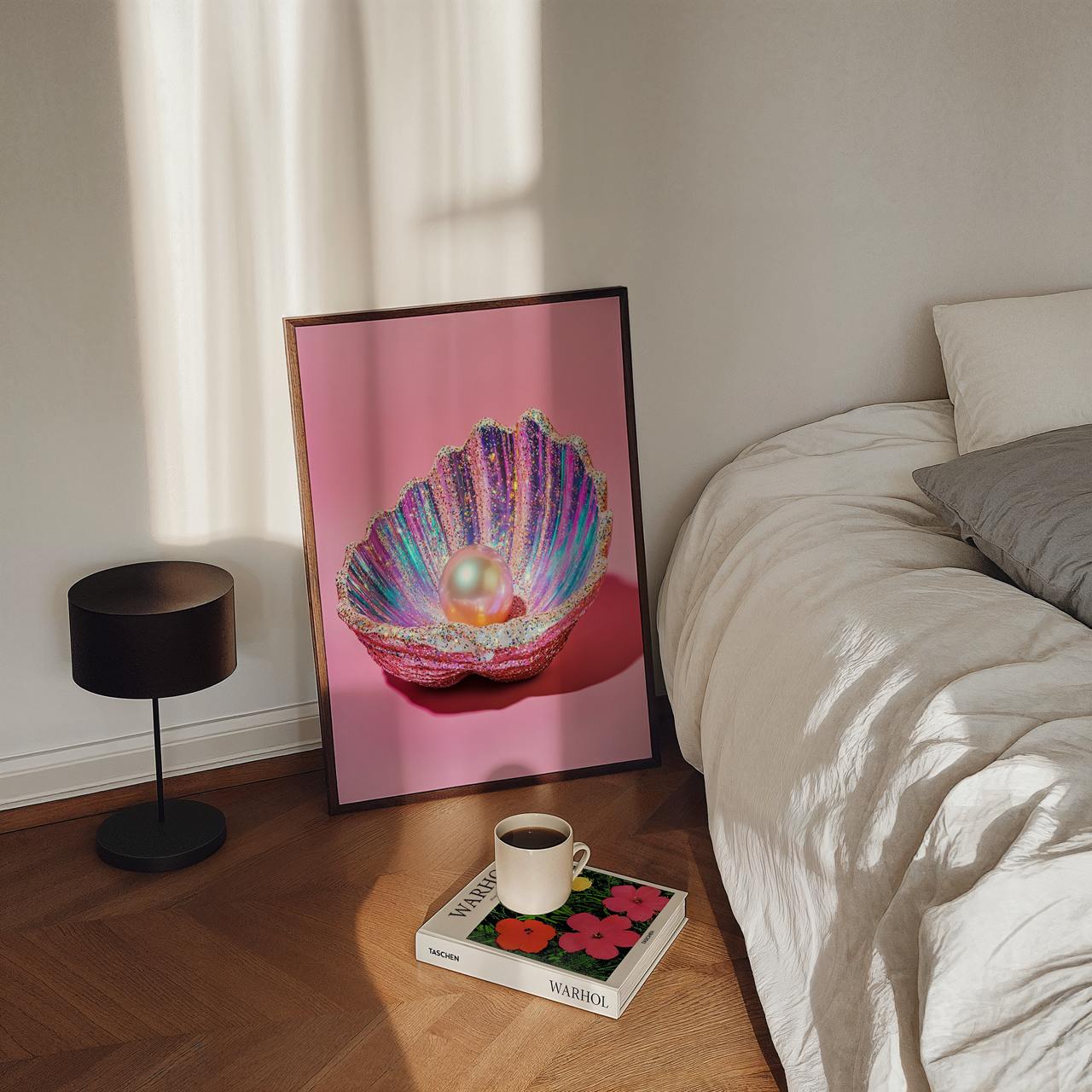 Framed artwork of a colorful shell with a pearl on a pink background, placed on a wooden floor next to a bed.
