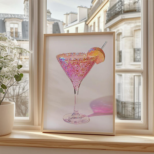 Framed artwork of a pink cocktail with a lemon wedge on a windowsill.
