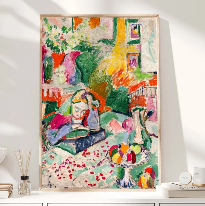 A colorful painting of a young girl reading a book at a table, surrounded by fruit, vases, and a lively, abstract interior. The composition is filled with bold greens, reds, and pastels, with expressive brushstrokes creating a vibrant and energetic atmosphere.