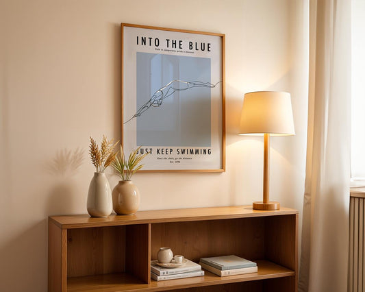Framed poster on a wall above a wooden shelf with decor items.