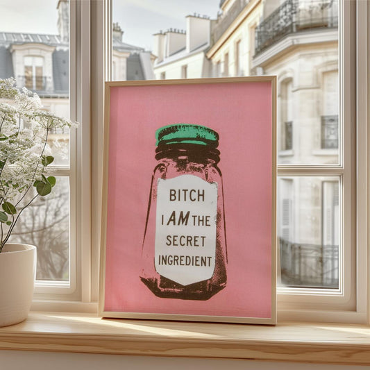 Framed artwork with a pink background and text on a windowsill.