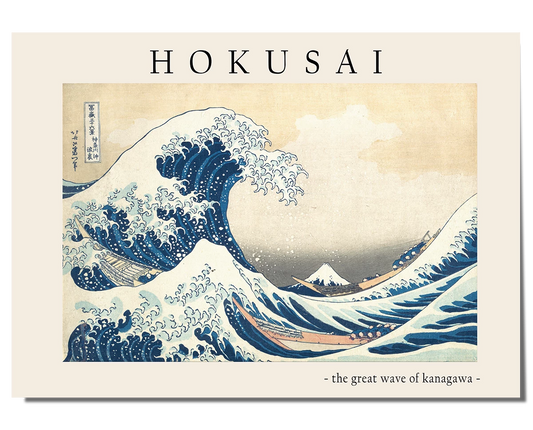 A Japanese woodblock print featuring a large, curling blue wave with foamy white edges dominating the scene. Small boats are caught in the turbulent water, while Mount Fuji appears in the distance beneath a soft beige sky. The artwork is framed by a cream-colored border, with "Hokusai" written at the top and "The Great Wave of Kanagawa" at the bottom in an elegant font.
