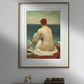 The first image features a framed poster of Frederick Leighton's painting "Psamathe" hanging on a gray wall. The artwork depicts a nude woman sitting on the shore, wrapped in a white cloth, gazing out at the ocean. The frame has a golden border, adding a touch of elegance. Below the poster, a modern workspace setup is visible, including books, and a turntable.