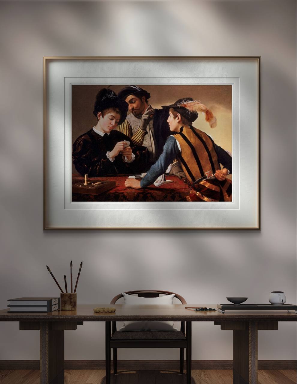 The framed "The Cardsharps" painting is displayed above a minimalist wooden desk, illuminated by soft lighting. The setting is a dimly lit room, emphasizing the rich colors and dramatic scene in the artwork.