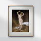 The same classical painting of a nude woman, framed elegantly in white and gold, hangs on a minimalist white wall. The surrounding decor is simple, enhancing the artwork's prominence.
