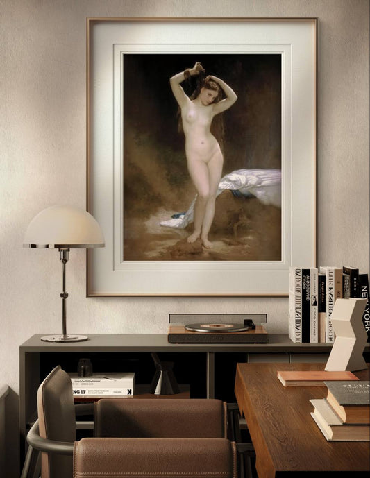 The framed painting of a nude woman is displayed in a cozy home office, above a dark wooden desk and bookshelf. Warm lighting and earthy tones in the room complement the artwork's serene beauty.