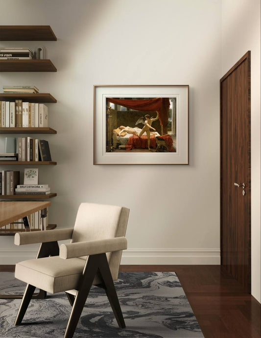 The framed painting of Cupid and Psyche hangs in a sophisticated room with wooden shelves and a beige armchair. The modern, clean decor complements the classical artwork.
