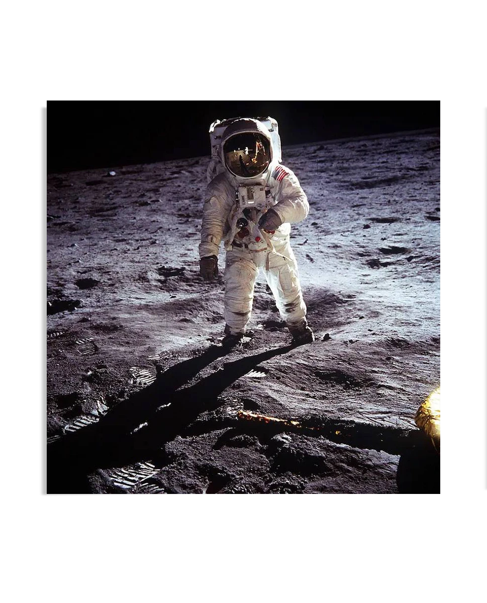 This poster showcases one of the most iconic images in history: astronaut Buzz Aldrin standing on the surface of the moon during the Apollo 11 mission. The astronaut is fully suited, with the American flag patch visible on his arm, standing on the rugged lunar landscape with a dark sky in the background. The image captures a monumental moment of human achievement and space exploration, making this Buzz Aldrin Poster an extraordinary addition to any Wall Art collection. Ideal for space enthusiasts, this Art-