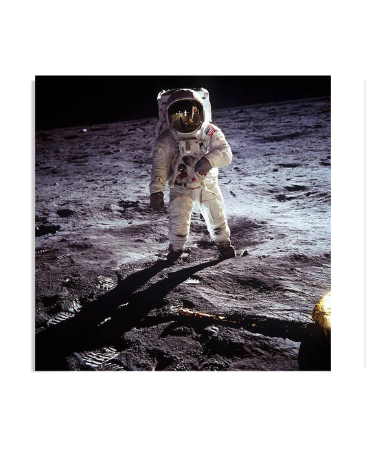 This poster showcases one of the most iconic images in history: astronaut Buzz Aldrin standing on the surface of the moon during the Apollo 11 mission. The astronaut is fully suited, with the American flag patch visible on his arm, standing on the rugged lunar landscape with a dark sky in the background. The image captures a monumental moment of human achievement and space exploration, making this Buzz Aldrin Poster an extraordinary addition to any Wall Art collection. Ideal for space enthusiasts, this Art-