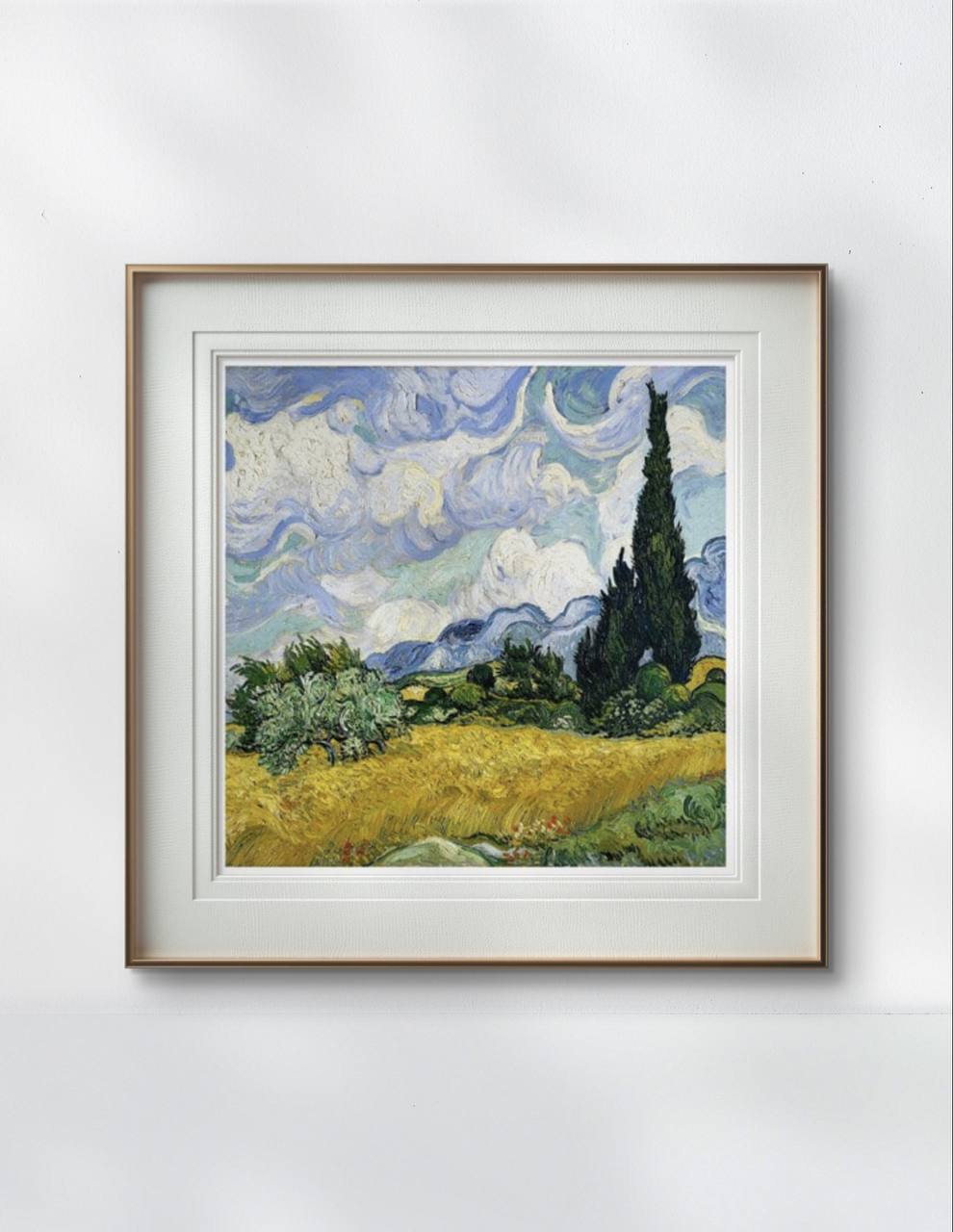 The framed reproduction of Van Gogh's "Wheat Field with Cypresses" hangs in a simple, modern room. The artwork's rich colors and energetic brushstrokes contrast beautifully with the room's neutral decor, adding a vibrant focal point.