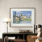 Framed impressionist painting of a river and bridge, hanging in a cozy home office. The serene scene of boats and houses bathed in sunlight adds a calming, picturesque touch to the room.