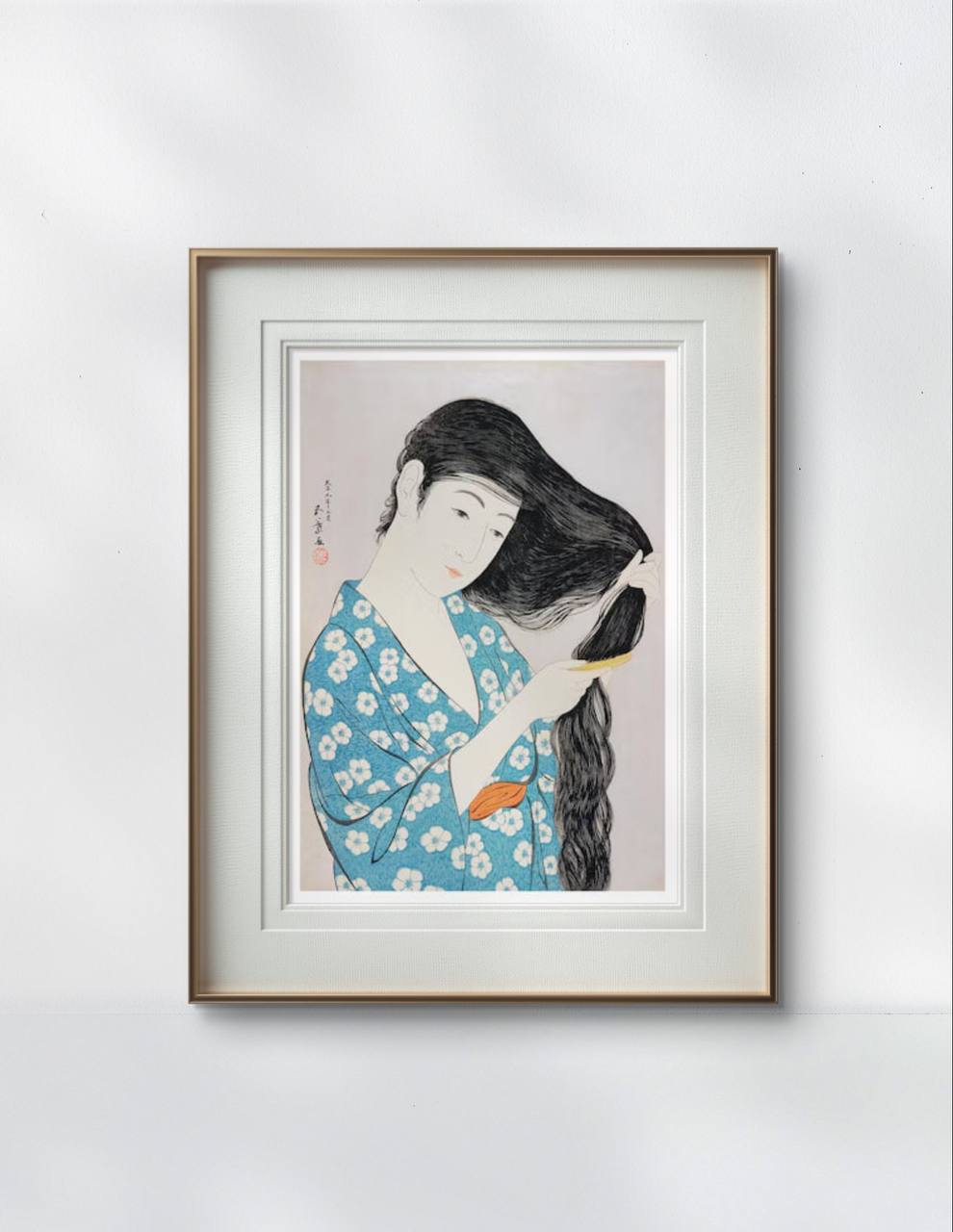 Framed print of a Japanese woman in a blue kimono combing her hair. The serene and graceful illustration brings a calming and artistic presence to the room's decor.