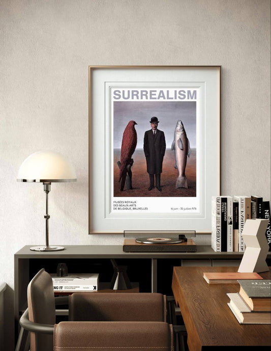 A framed surrealist poster hangs above a desk with books and a vinyl player. The man in a suit stands between a red bird and a fish. The scene blends modern decor with artistic flair