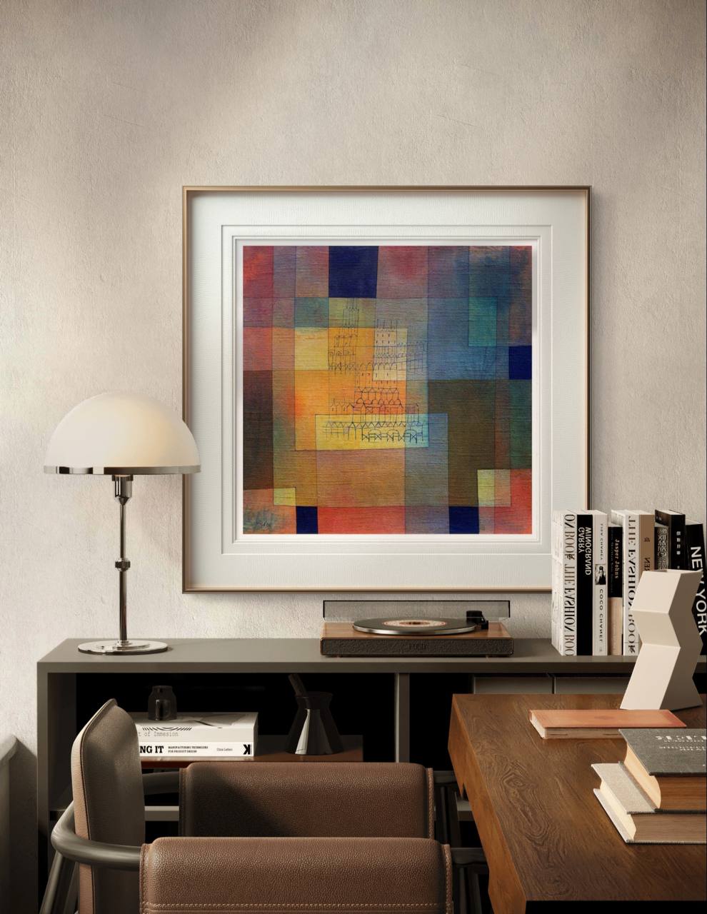 A framed abstract print by Paul Klee showcasing geometric shapes in warm and cool tones. The detailed architectural lines within the bold colors create a harmonious contrast in the modern room.