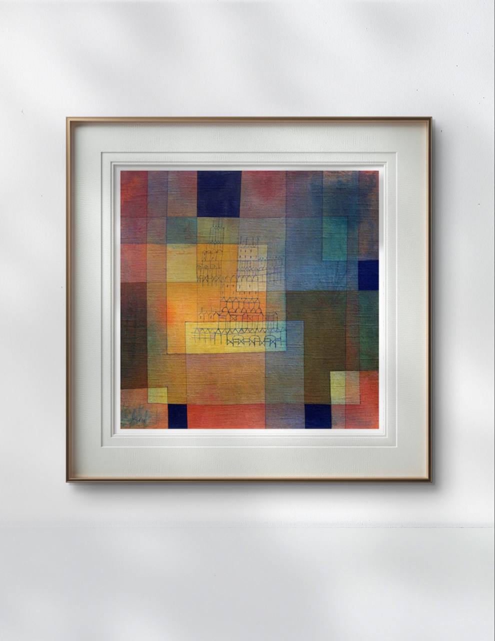 A framed abstract painting by Paul Klee hangs in a minimalist office. The vibrant geometric shapes and architectural patterns bring depth and energy to the room's simple, clean decor