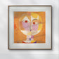 A framed print of 'Senecio' by Paul Klee hangs in a minimalist office. The geometric face in shades of orange and pink creates a striking contrast with the clean lines of the room's design
