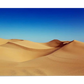 A stunning desert landscape with golden sand dunes stretching across the horizon. The smooth curves of the dunes contrast with the deep blue sky, creating a calm and expansive view.