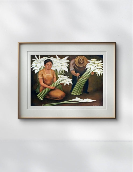 The framed painting hangs on a simple white wall. The earthy tones of the painting, along with the white lilies and traditional figures, create a vibrant contrast against the minimalist background.