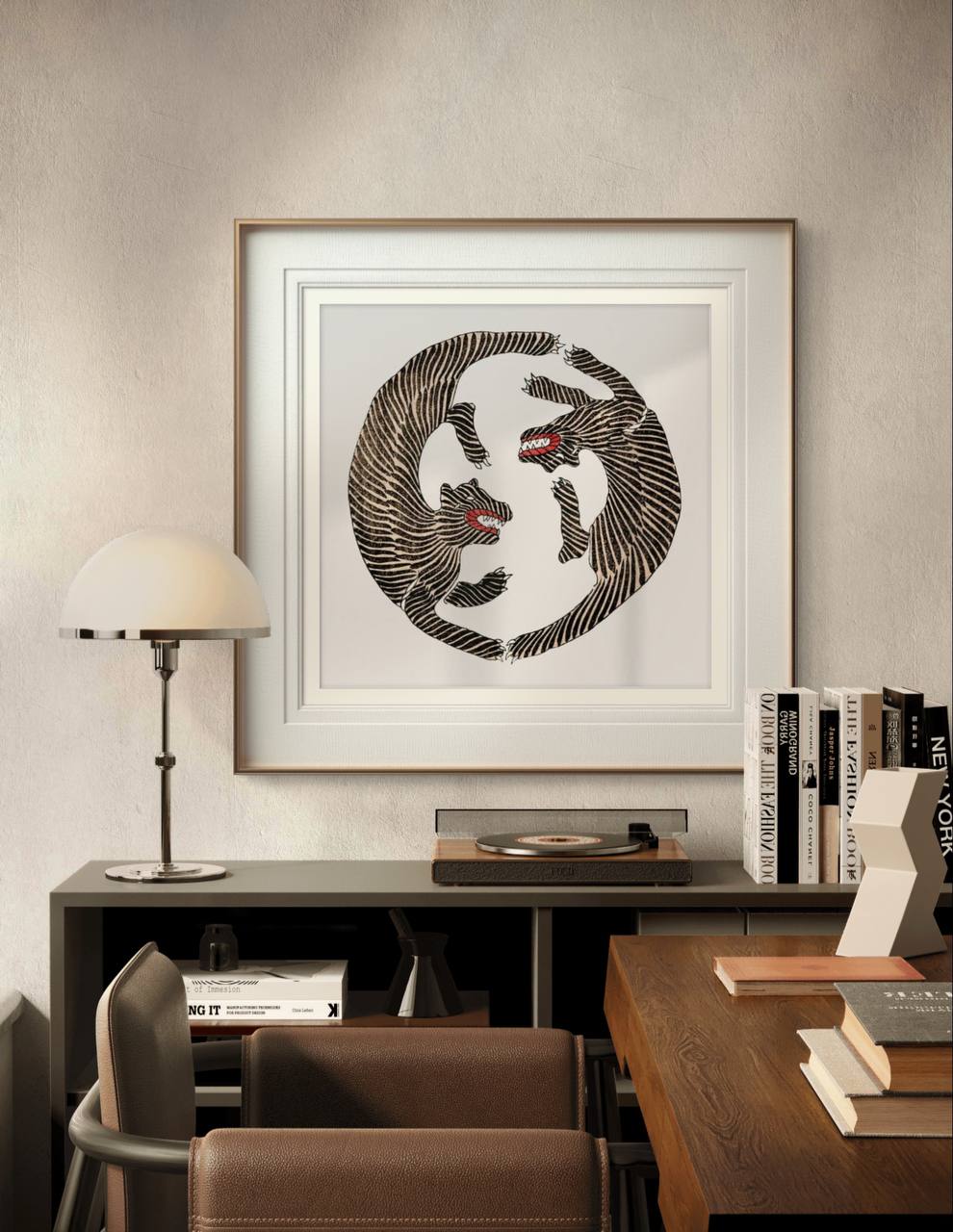  The same framed illustration of two tigers is shown in a modern workspace. It hangs above a desk with books and a record player, blending vintage Japanese art with a sleek, contemporary interior design.