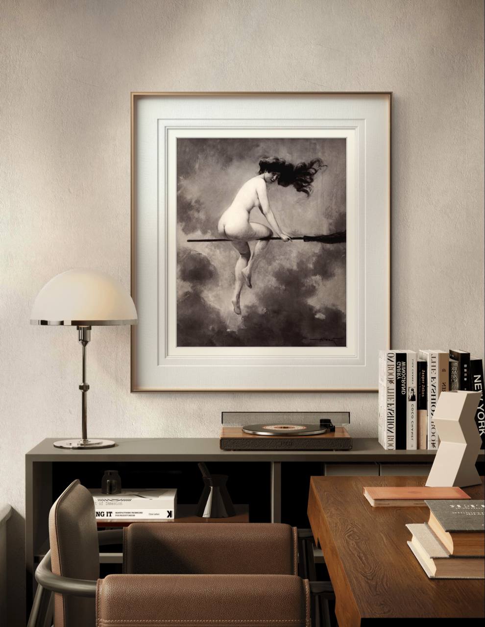 The framed artwork of the woman on a broomstick is displayed in a modern interior. The contrast of the vintage-style monochrome image with the clean, minimalist decor creates a striking focal point in the room.