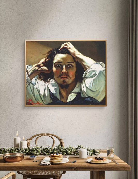 : A framed portrait of a man in panic, hung above a rustic dining table set with breakfast plates and candles. The painting's intense expression contrasts with the serene setting of the room.