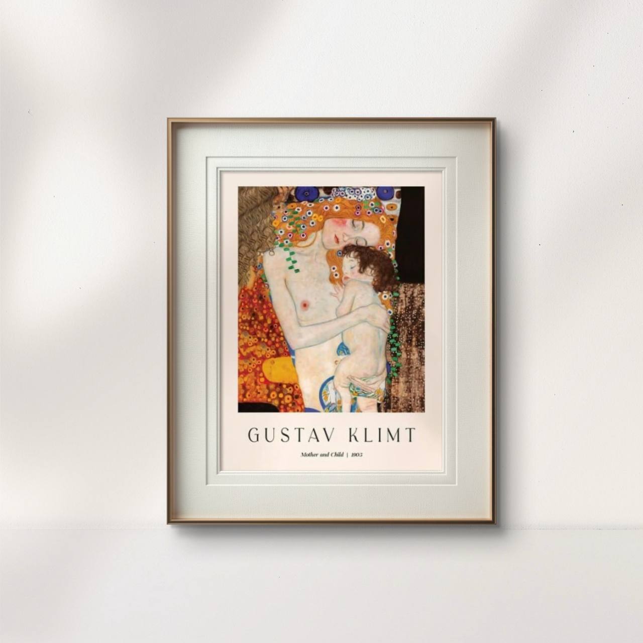 A framed poster of Gustav Klimt’s "Mother and Child," displayed in a minimalist room. The vibrant colors of the artwork add warmth to the decor, highlighting the intimate bond between mother and child.