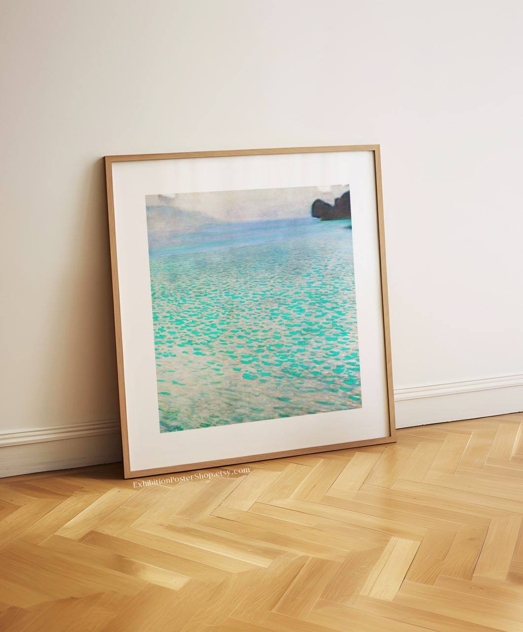  A framed painting of a peaceful lake scene, leaning against a white wall. The water's turquoise hues stand out, reflecting light beautifully, and the artwork's simplicity brings a calming effect to the minimalist space.