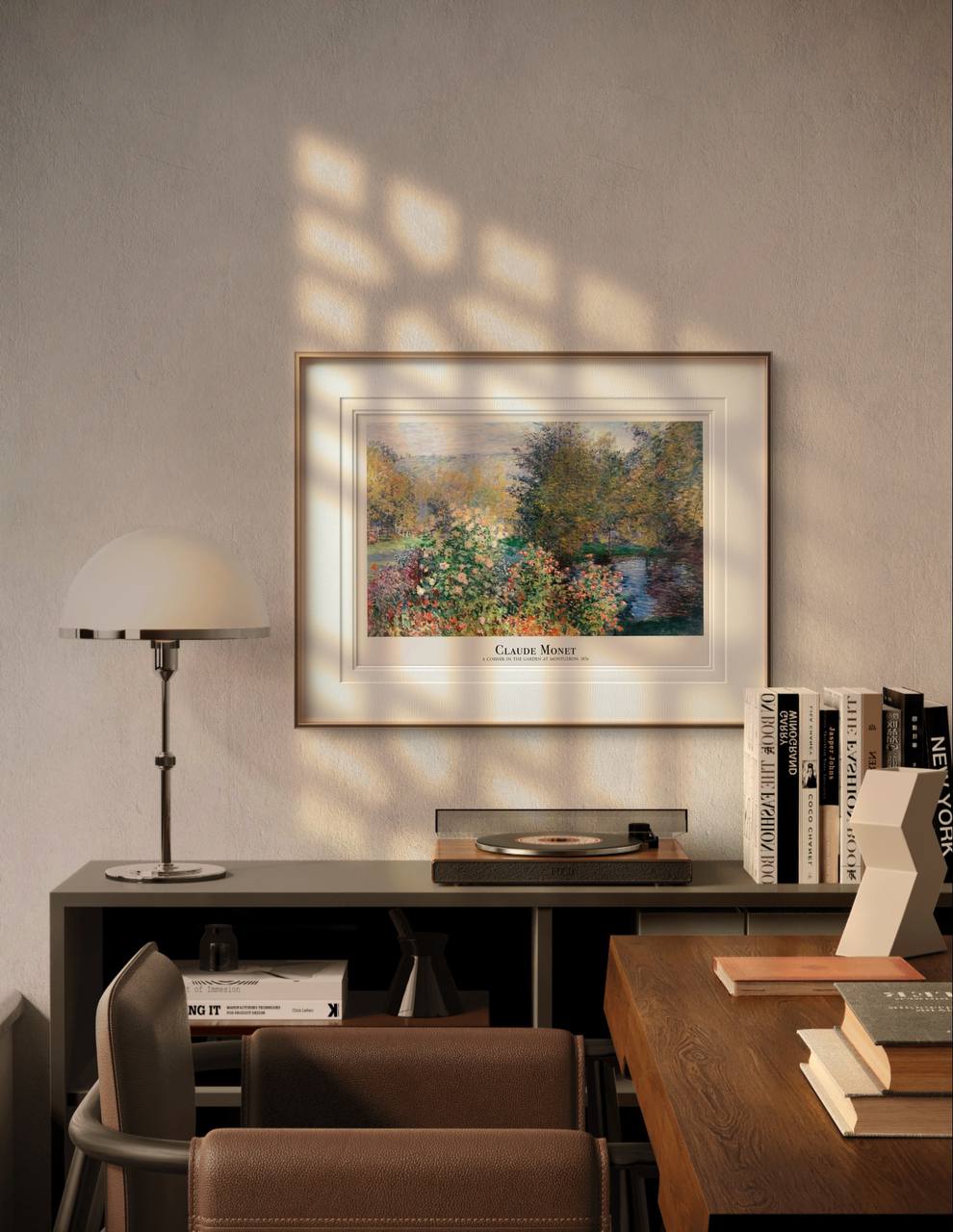 The framed artwork, labeled “Claude Monet – A Corner in the Garden at Montgeron,” is displayed above a desk with a lamp and books. The natural light highlights the peaceful and vibrant garden scene.