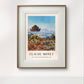The framed painting showcases a view of Antibes with a vibrant blue sky and lush greenery in the foreground. The simple, elegant frame brings the artwork to life, adding depth and brightness to the surrounding space.