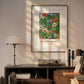 A Claude Monet poster featuring the "Anémones en Pot" painting, framed and hung above a modern desk with books and a lamp. The room is softly lit, highlighting the artwork.