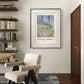 A framed Monet poster, "Poplars, Pink Effect," hangs on a modern wall near a cozy chair and shelves filled with books, giving the space a serene and artistic feel.