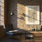 Modern living room with a brick wall, window, and framed poster of a basketball player.