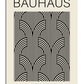 A modernist black-and-white poster featuring the word "Bauhaus" in bold, uppercase letters at the top. Below, an intricate geometric pattern of repeating arches and parallel lines creates a visually dynamic composition. The bottom section contains small text reading "July - August 1923 Weimar Exhibition," referencing the historical Bauhaus event. The overall design is minimalist, structured, and aligned with the Bauhaus movement’s clean, functional aesthetic.

