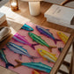 Colorful fish illustration on a pink background on a wooden table with books and a lamp.