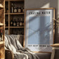 Framed poster with 'Chasing Water, Just Keep Swimming' text in a cozy room with a bookshelf and chair.