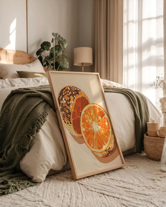 Framed artwork of dried oranges on a bed in a bedroom with natural light.