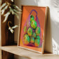 Framed artwork of a bag with green apples on an orange background