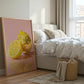 Bedroom with a bed, basket, and a painting of lemons on the wall.