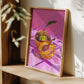 Framed artwork of a colorful disco ball apple on a wooden shelf.
