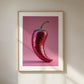 Framed artwork of a red disco pepper on a pink background