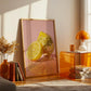 Modern interior with a decorative poster of a lemon and disco ball, orange table, and books.