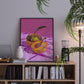 Framed artwork of a disco ball apple on a bookshelf with books and decor items.